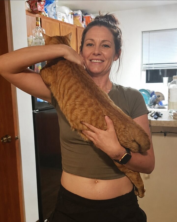 PetGearWise editor Angie holding her orange tabby cat Pumpkin
